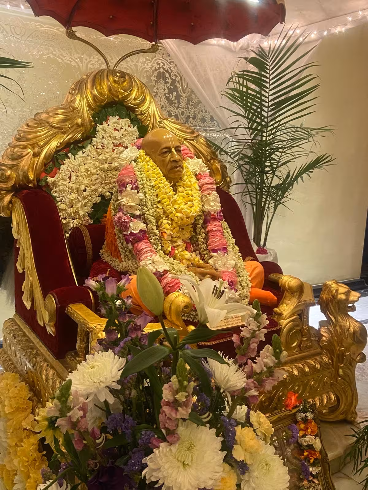 Close-up of Prabhupada with flower garlands